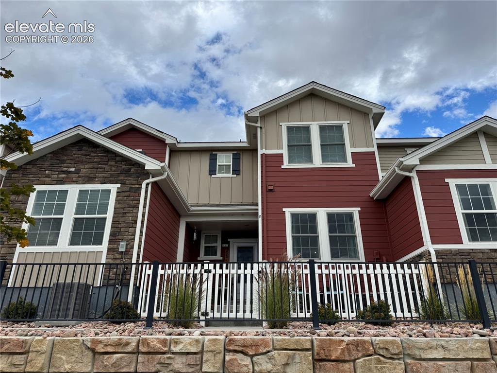 Image 1 of 25: Multi-level exterior featuring stone veneer accents, vertical and horizonta