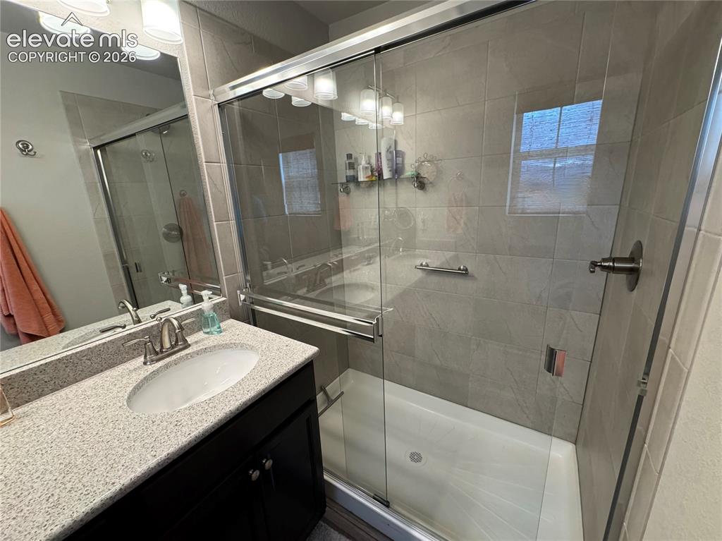 Image 16 of 25: Dark cabinetry with a light-toned countertop, oval undermount sink, large w