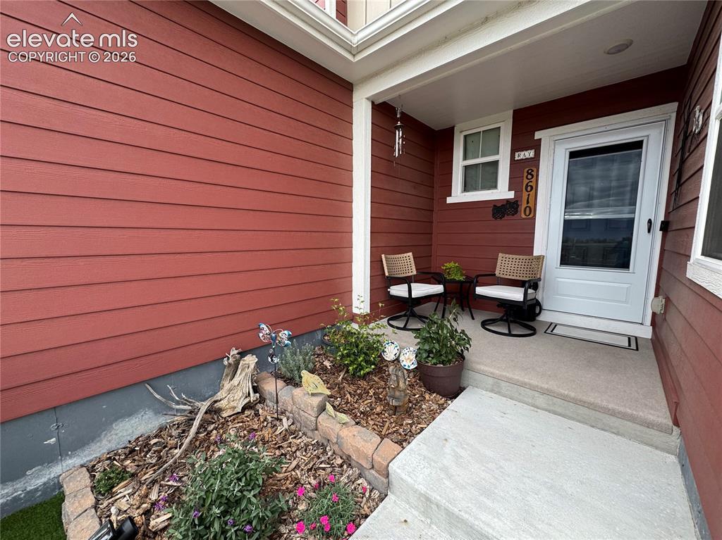 Image 21 of 25: Covered entryway featuring horizontal lap siding, a concrete porch, and a m