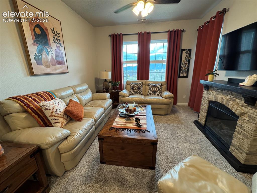 Image 3 of 25: Living room featuring a floor-to-ceiling stone fireplace surround, dark woo