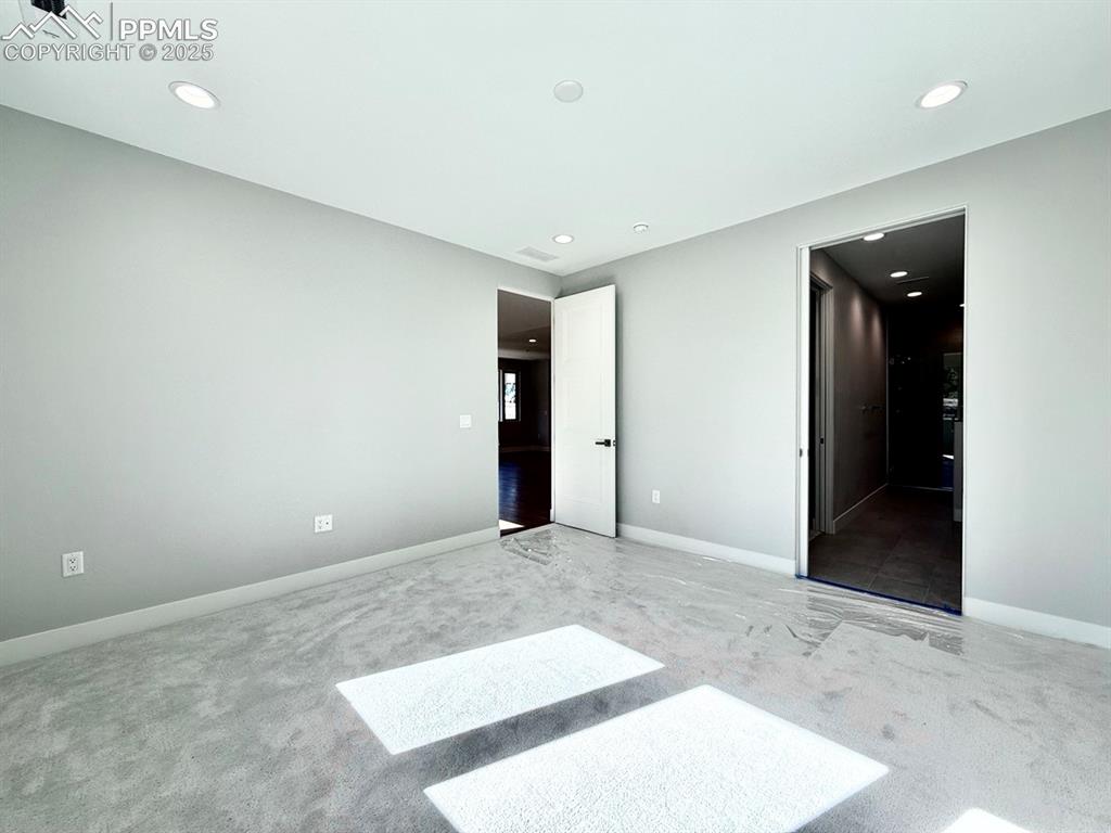Image 18 of 29: Main Level Primary Suite with Large Windows looking into the Forest and Car