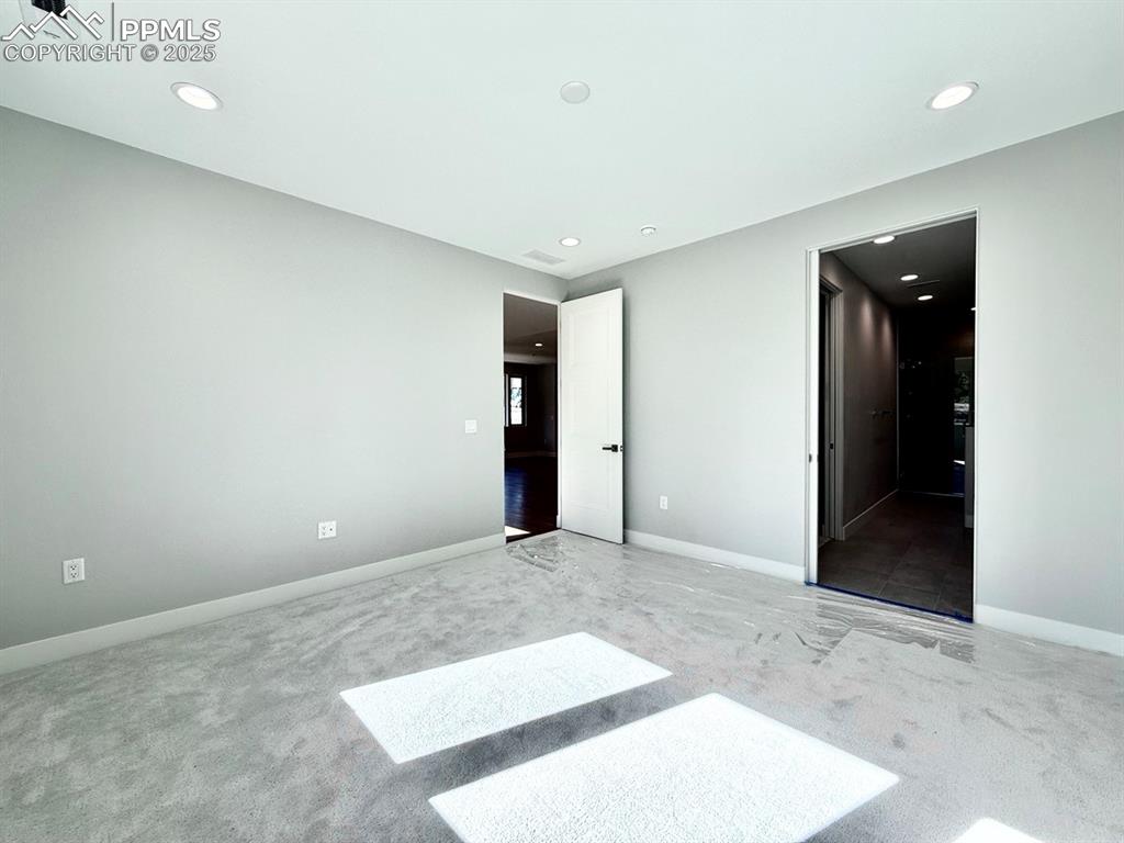 Image 20 of 28: Unfurnished bedroom with carpet flooring and recessed lighting