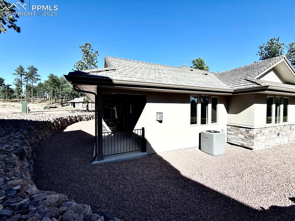Image 23 of 29: Stone and Stucco exterior with tiled roof make this low-maintenance.