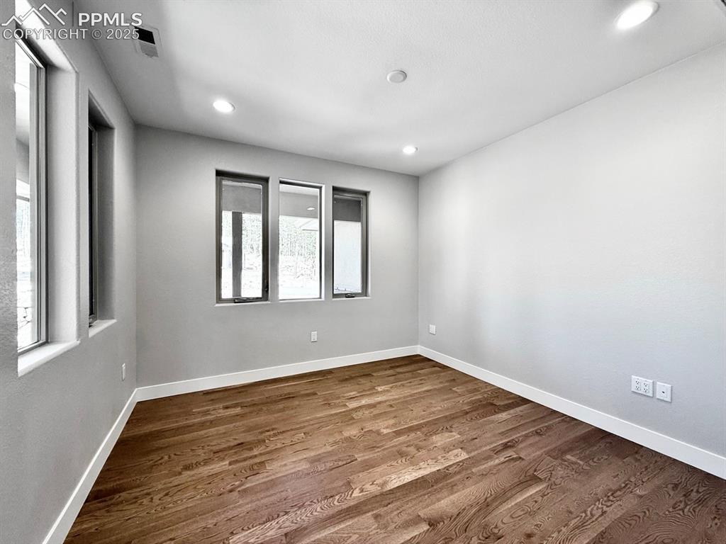 Image 3 of 29: The Office has large windows and wood flooring.