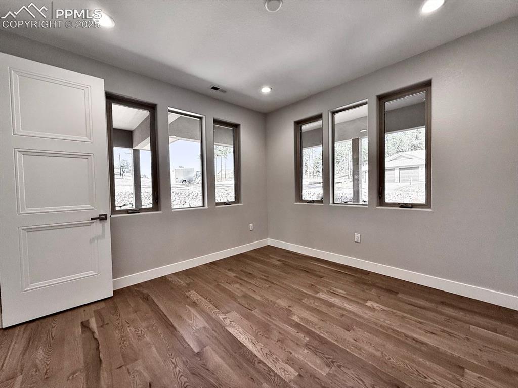Image 4 of 29: The Office has large windows and wood flooring.