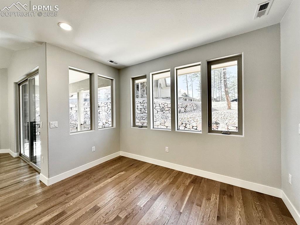 Image 6 of 29: Dining Room with Wood Flooring and Large Windows.
