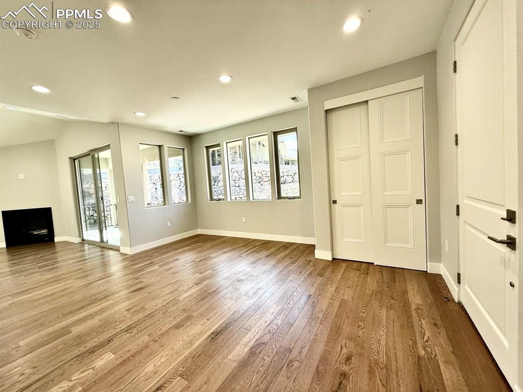 Image 7 of 28: Unfurnished living room featuring wood finished floors and recessed lightin