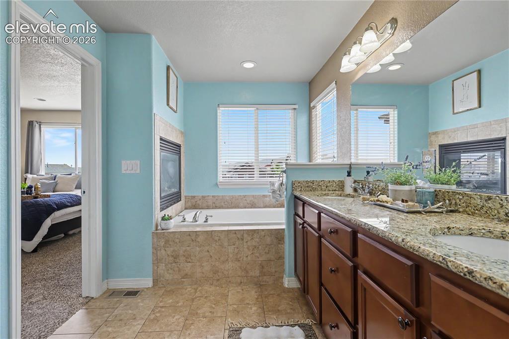 Image 19 of 38: Bathroom featuring a dual vanity with granite countertops and undermount si