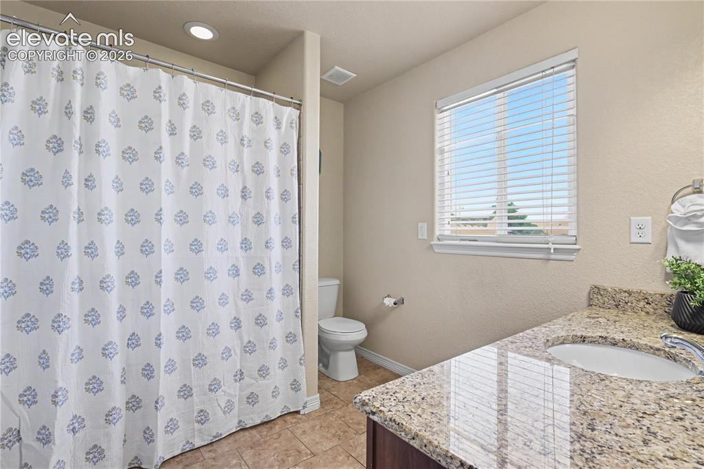 Image 23 of 38: Bathroom featuring a shower area, a single vanity with a granite-style coun