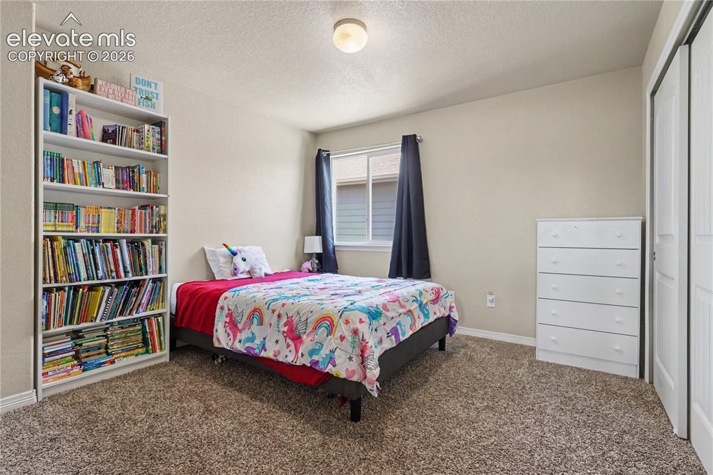 Image 25 of 38: Neutral wall paint, textured ceiling, and brown carpet flooring