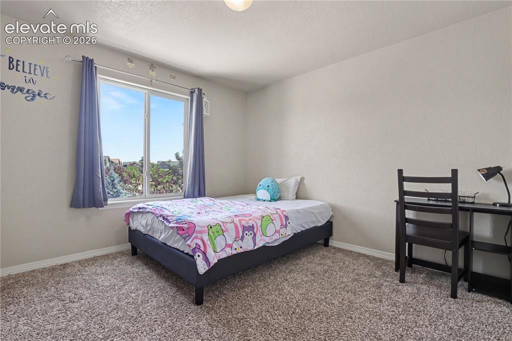 Image 27 of 38: Carpeted room featuring a large window, neutral wall tones, and a light fix