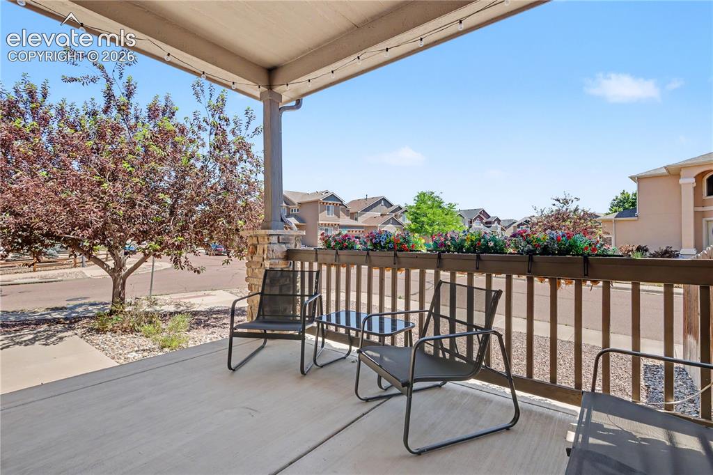 Image 35 of 38: Covered porch featuring concrete flooring, a stone-wrapped column, and a wo