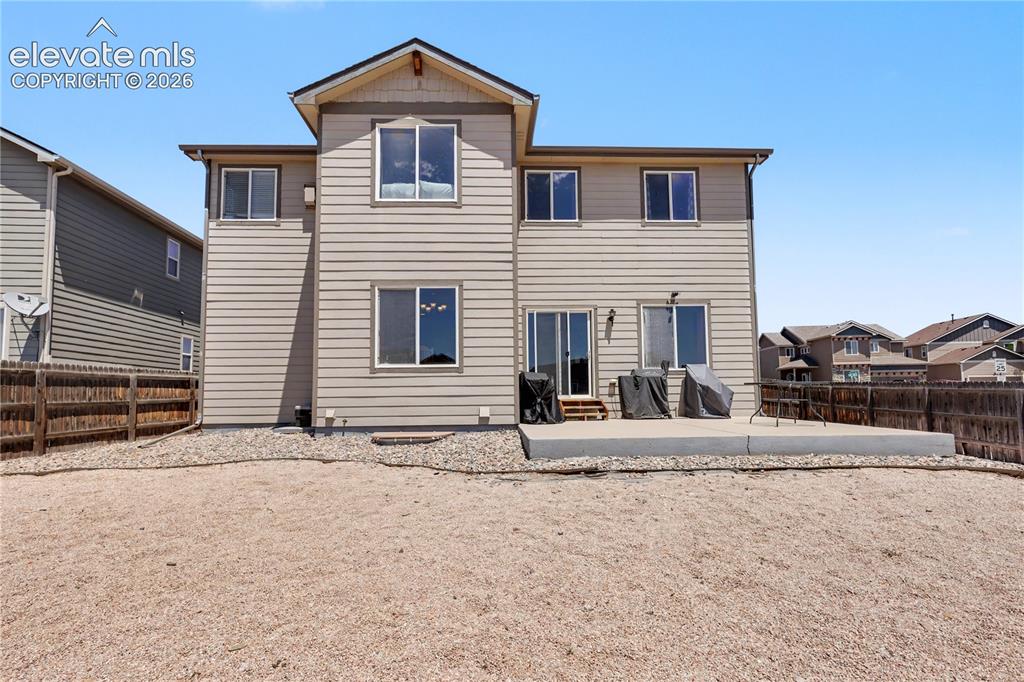 Image 37 of 38: Rear exterior with light beige siding and white trim