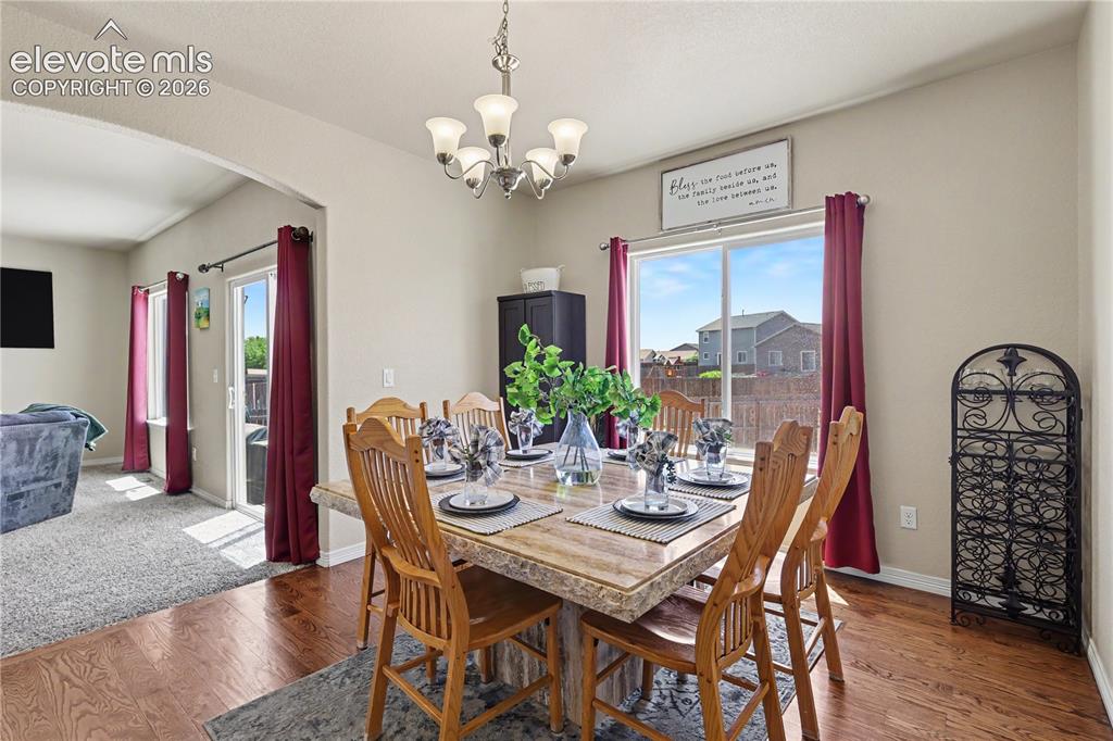 Image 9 of 38: Dedicated dining area featuring wood-finish flooring, a contemporary chande