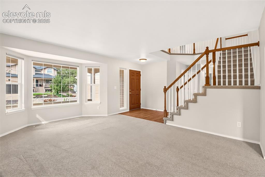 Image 25 of 42: Heading Upstairs, Wood Floors Leading Into The Kitchen, Garage Entry, And M