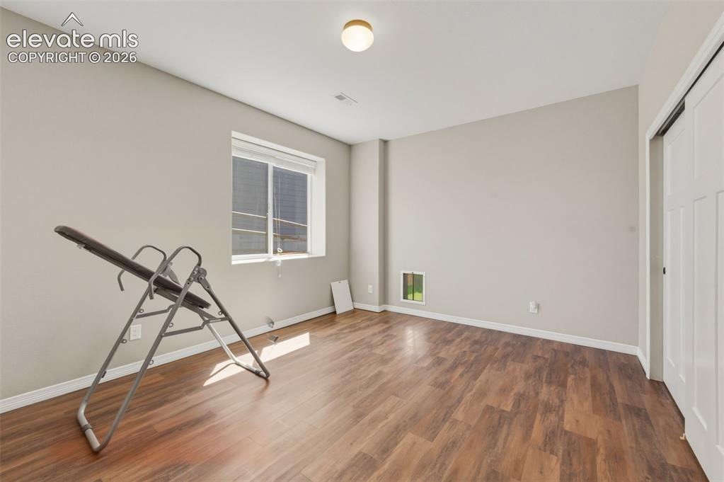 Image 26 of 42: Basement Bedroom with a Dog Door that leads to Fenced in Dog Run with turf.