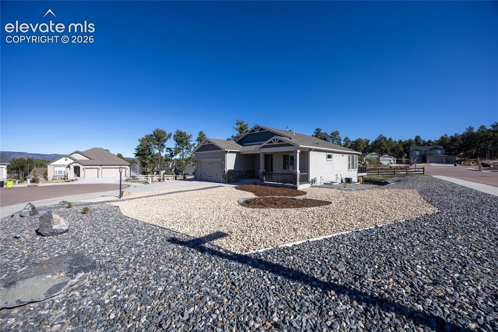 Image 15 of 48: Single-story residence featuring a covered front porch, attached two-car ga