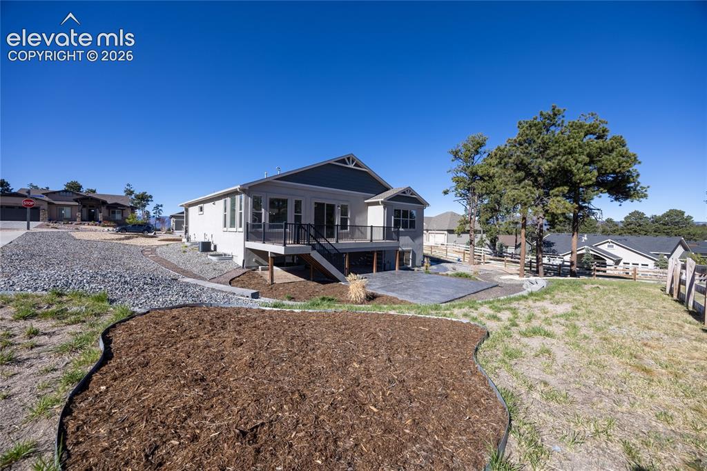Image 21 of 48: Rear elevation featuring a multi-level deck with black railings, a walk-out