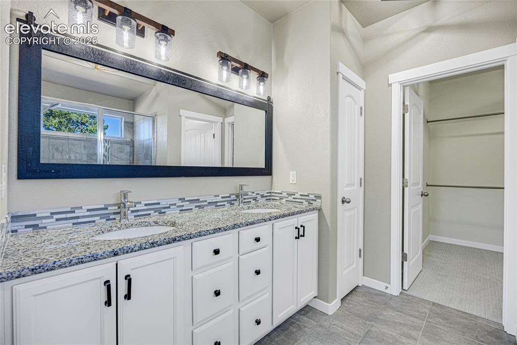 Image 25 of 48: Double vanity with speckled countertop and dual undermount sinks