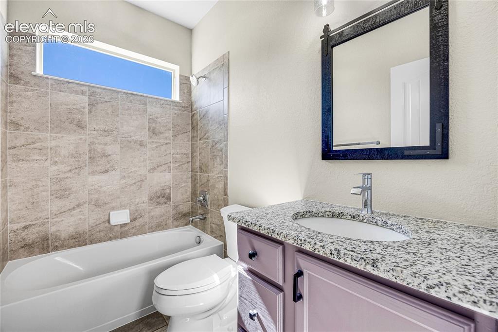 Image 36 of 48: Bathroom featuring a vanity with a granite countertop, undermount sink, and