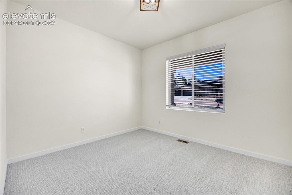 Image 37 of 48: Neutral wall finishes, light-toned carpeting, and a window with horizontal