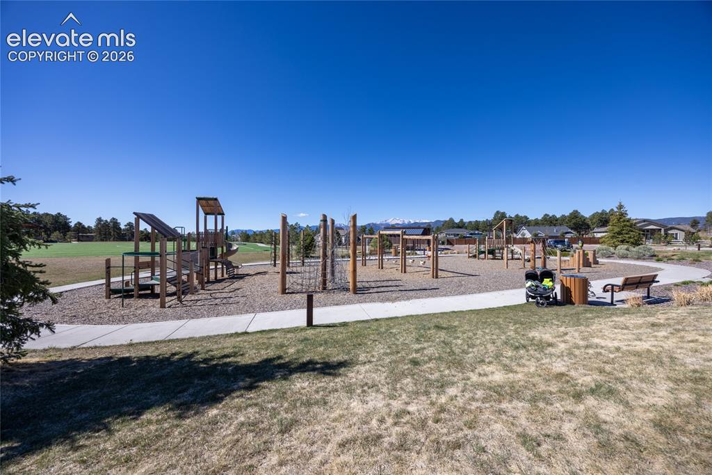 Image 48 of 48: Expansive playground with multiple play structures, a surrounding paved pat