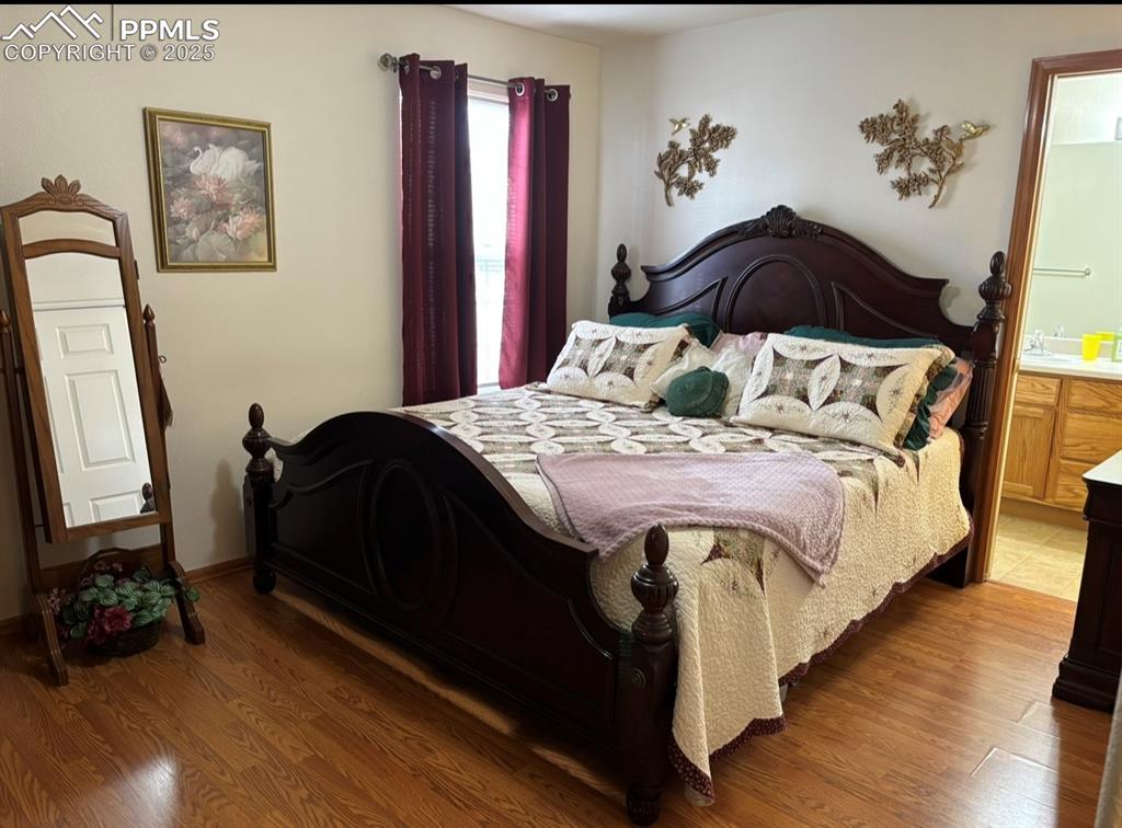 Image 12 of 15: Bedroom featuring wood finished floors and ensuite bathroom