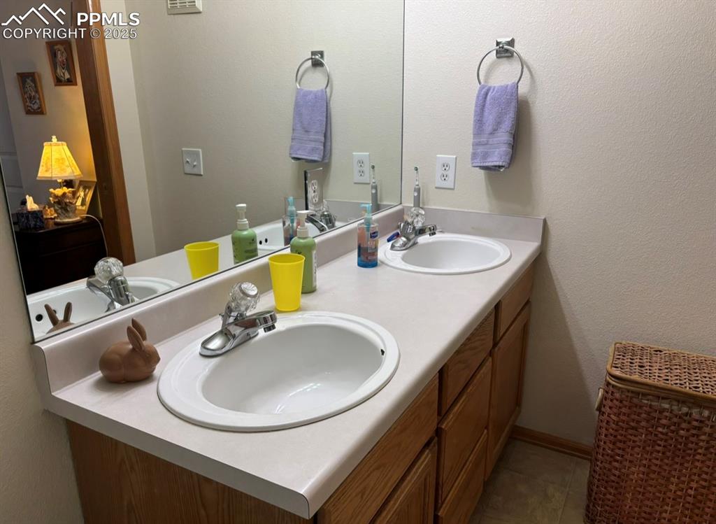 Image 14 of 15: Bathroom with double vanity and a textured wall