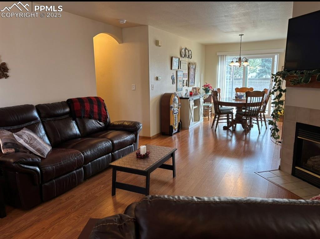 Image 3 of 15: Living area featuring wood finished floors, a fireplace, arched walkways, a