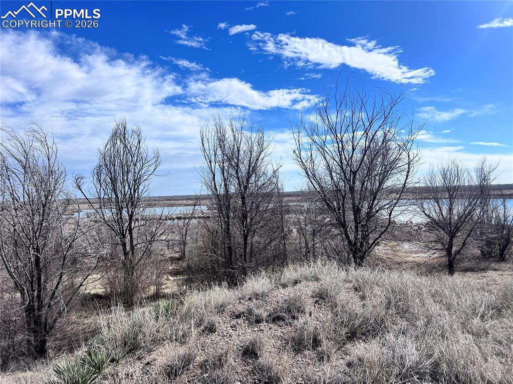 Image 24 of 33: Expansive land featuring a dirt track and a large arch-framed structure