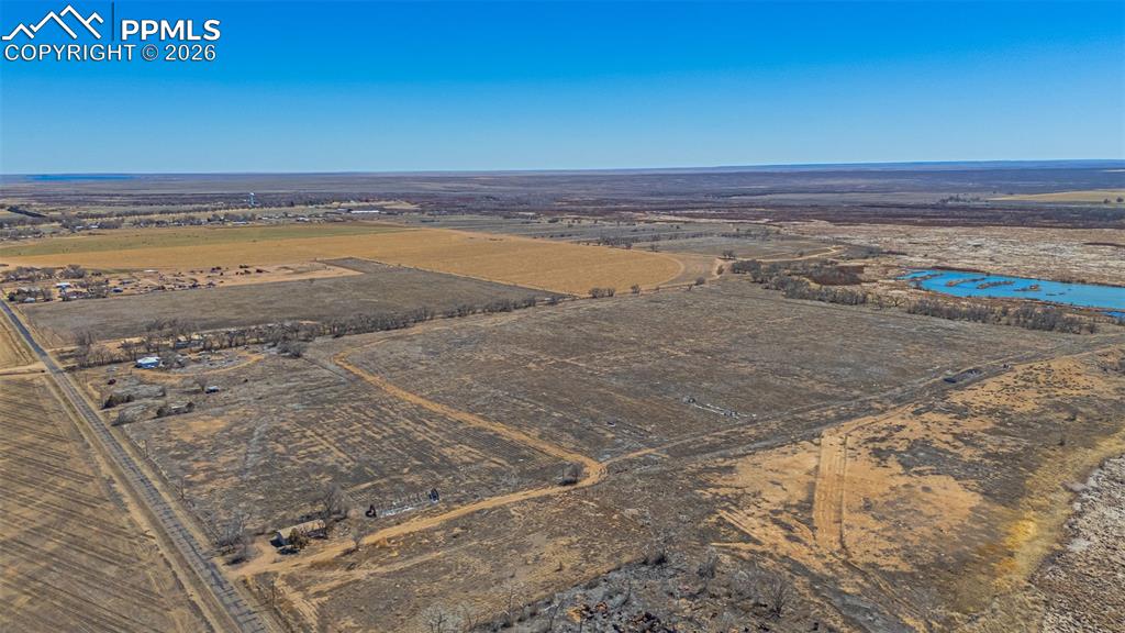 Image 29 of 33: This property features expansive land with a visible body of water, offerin