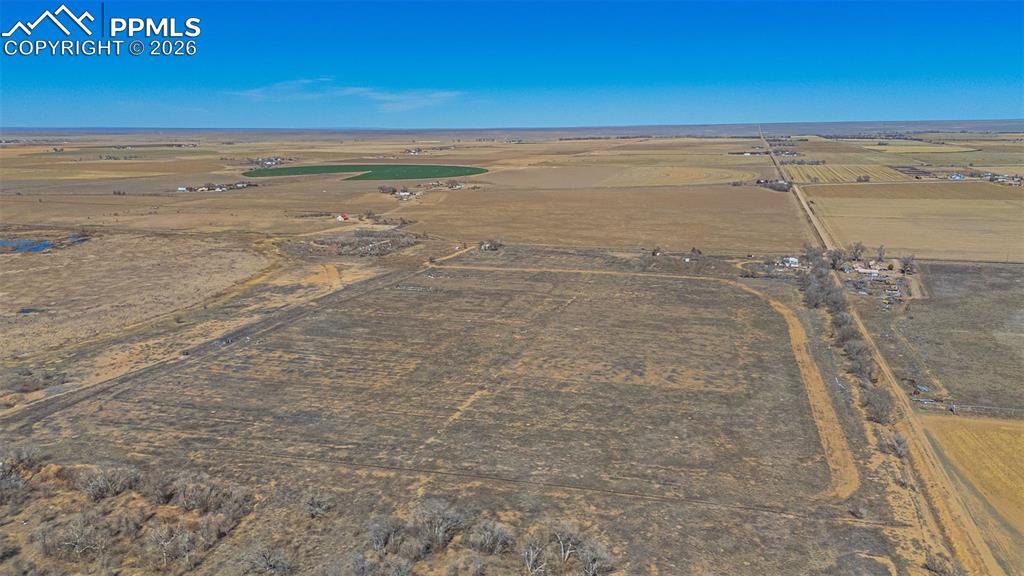 Image 32 of 33: The property encompasses a vast, open landscape with a clear blue sky overh