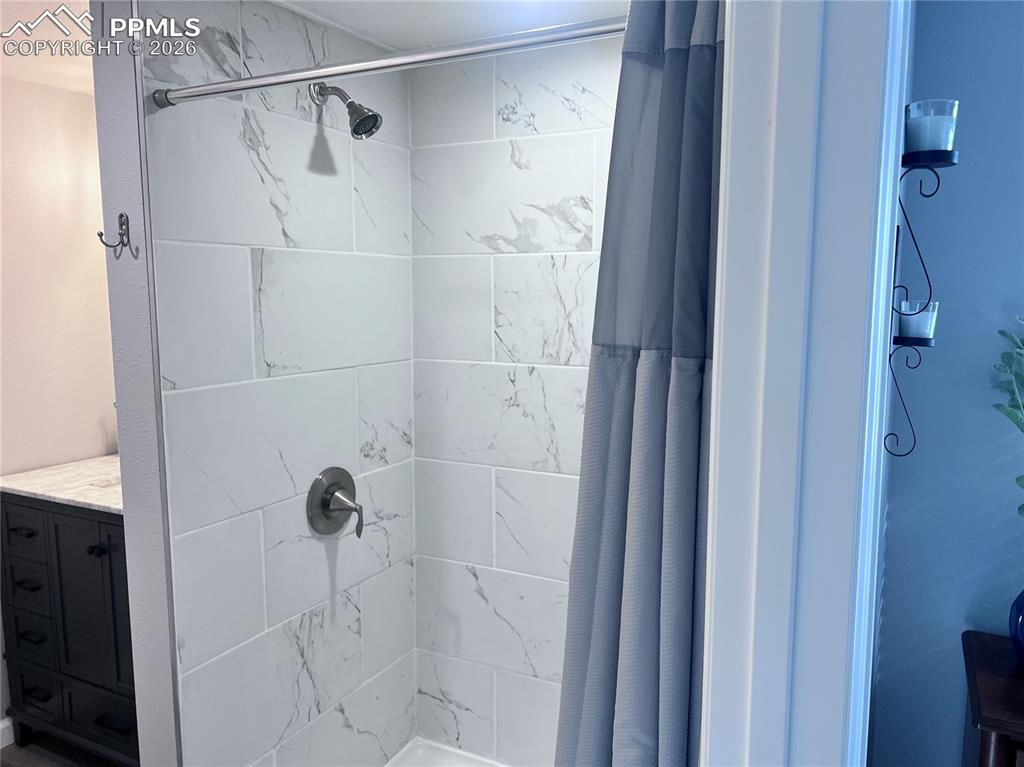 Image 9 of 33: This bedroom features durable grey plank flooring, light grey walls, and wi