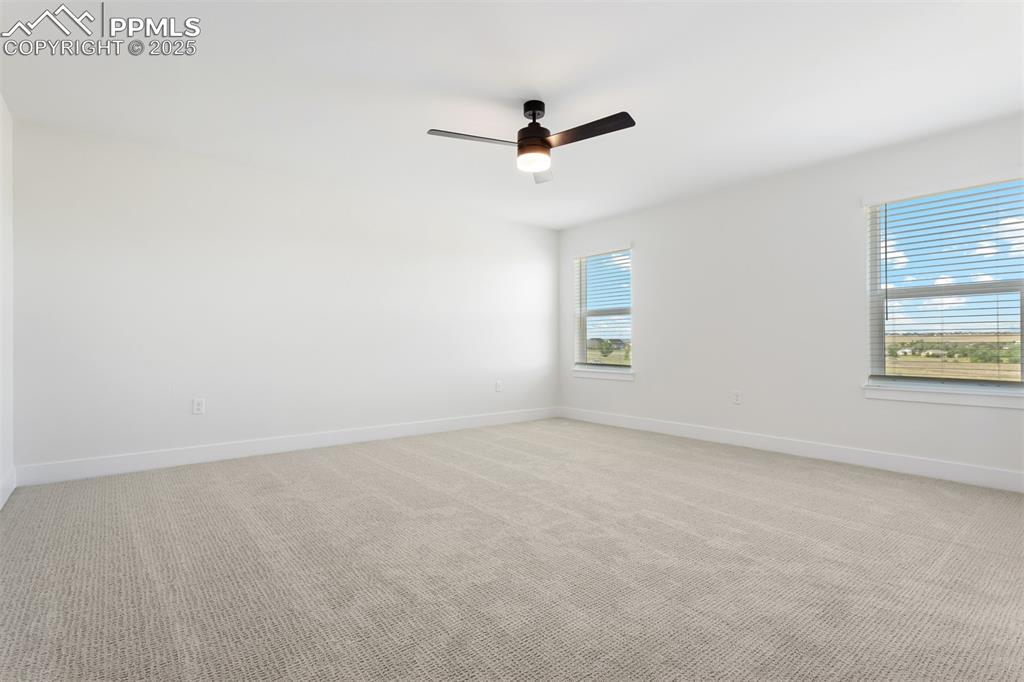 Image 8 of 20: Unfurnished room with light carpet, baseboards, and a ceiling fan