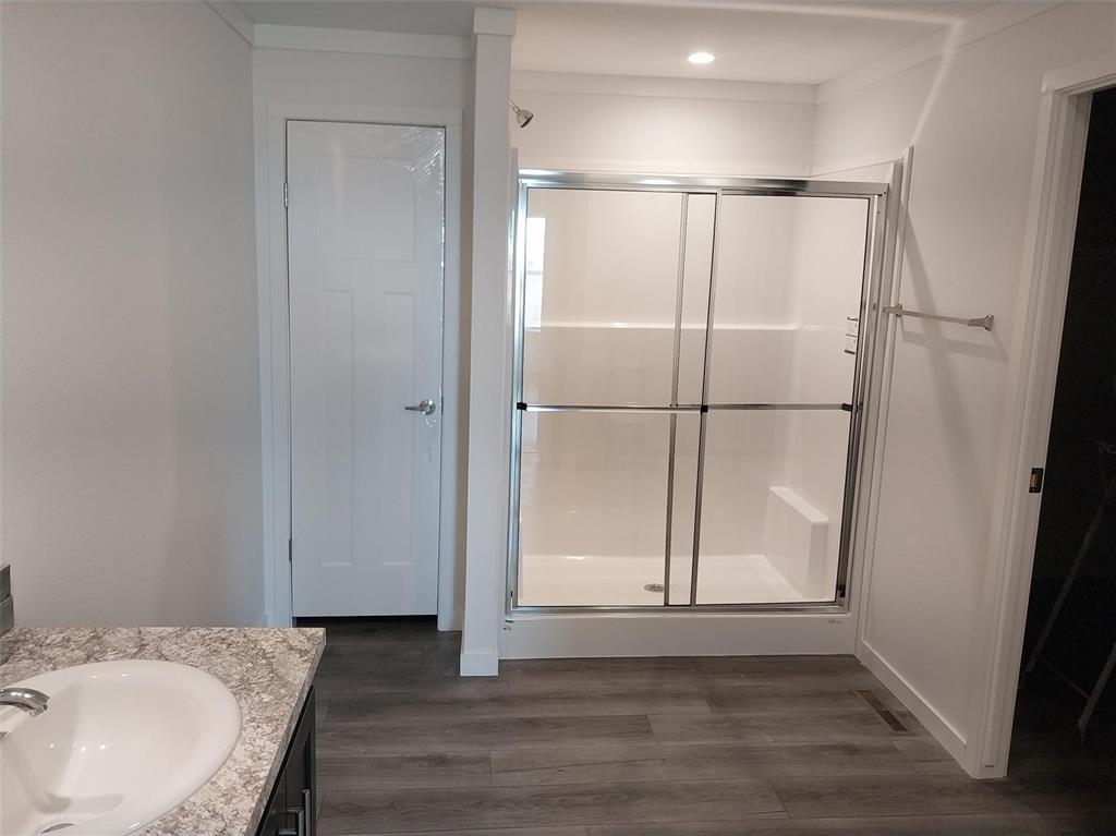 Image 10 of 25: Bathroom with vanity, dark wood-type flooring, and a shower stall