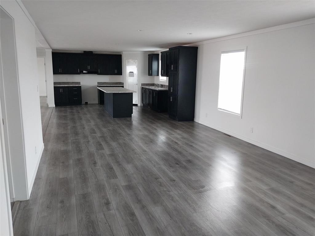 Image 22 of 25: Kitchen with dark cabinets, light countertops, dark wood finished floors, a