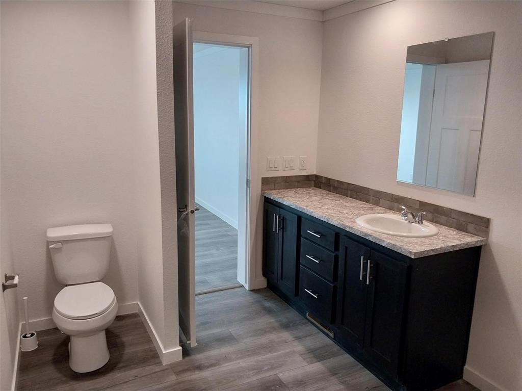 Image 7 of 25: Bathroom with vanity and dark wood-style floors