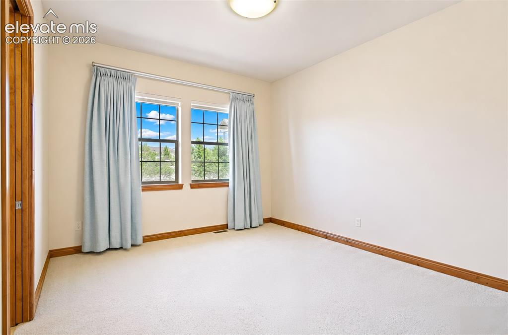 Image 42 of 48: Main level guest bedroom near front entry