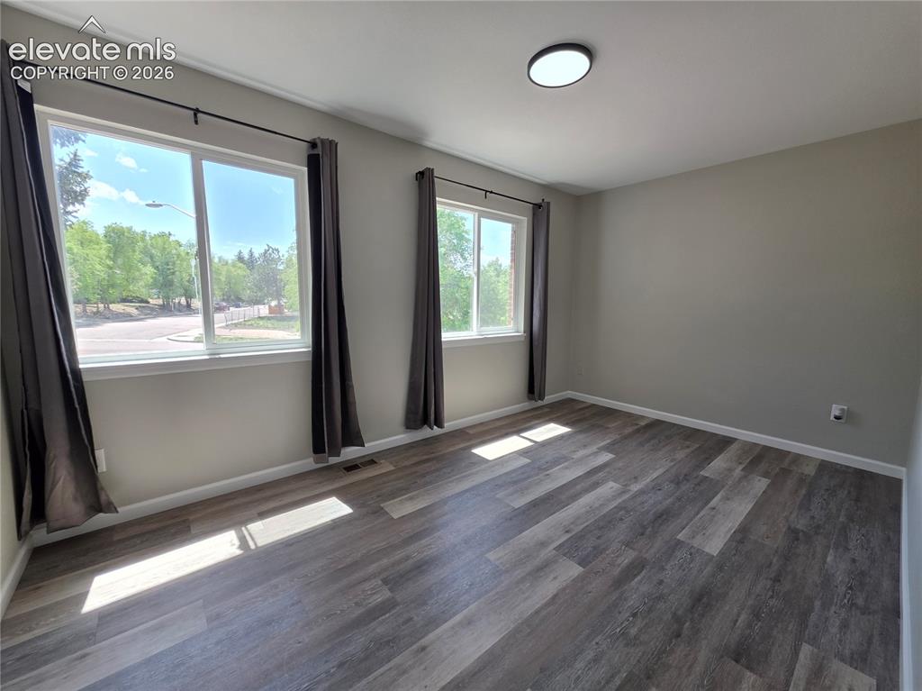 Image 11 of 18: Wood-finish flooring, multiple windows, flat panel lighting, neutral wall t