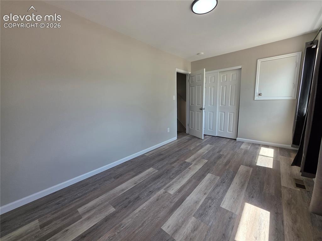 Image 12 of 18: Wood-finish flooring, neutral wall tones, and overhead lighting