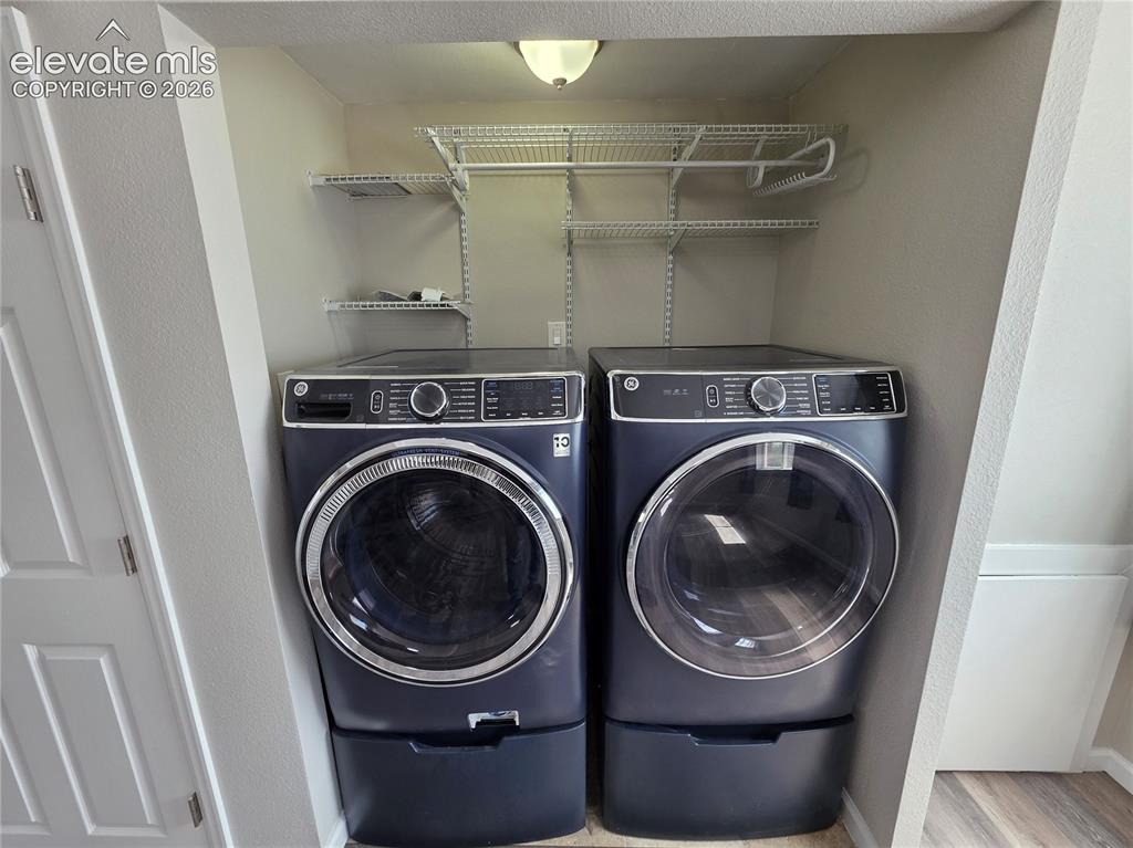 Image 15 of 18: Dedicated laundry area featuring a washer and dryer with pedestals, overhea