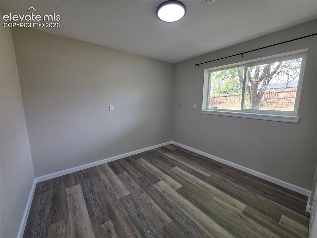 Image 16 of 18: Wood-finish flooring with white trim and neutral wall tones