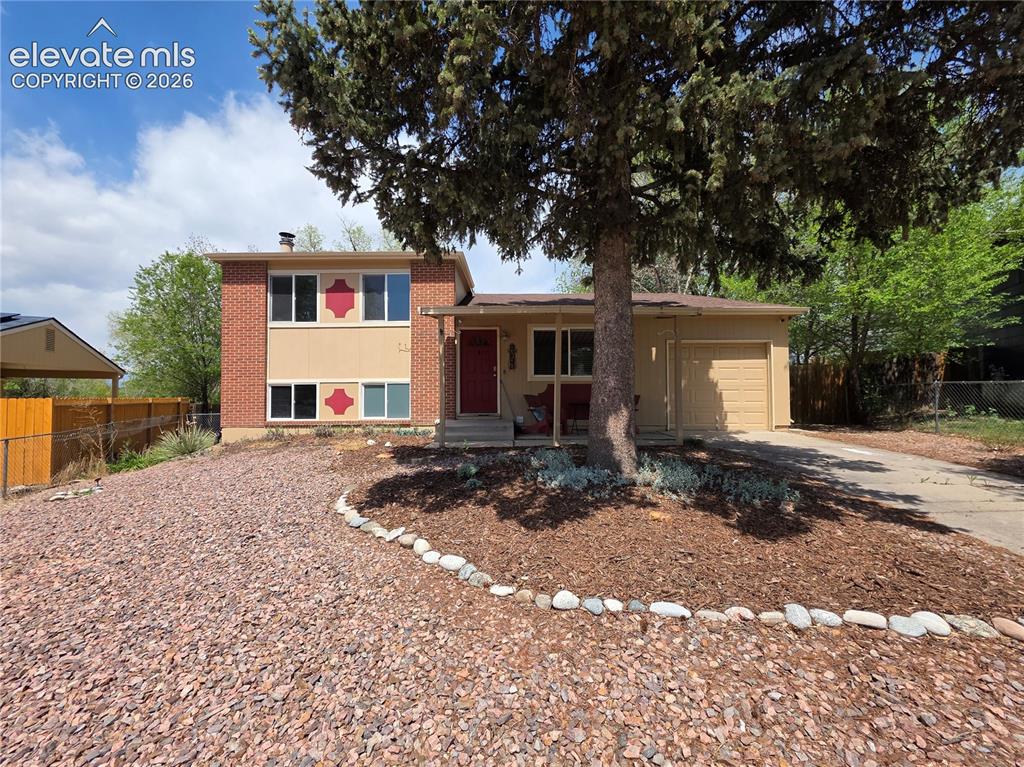 Image 2 of 18: Brick and stucco exterior with an attached garage, covered front porch, and