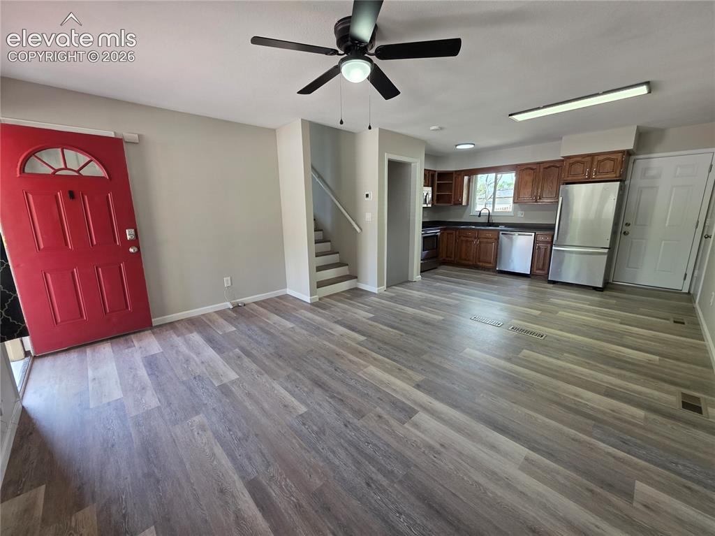 Image 4 of 18: Wood-finish flooring throughout, ceiling fan, and a kitchen featuring wood