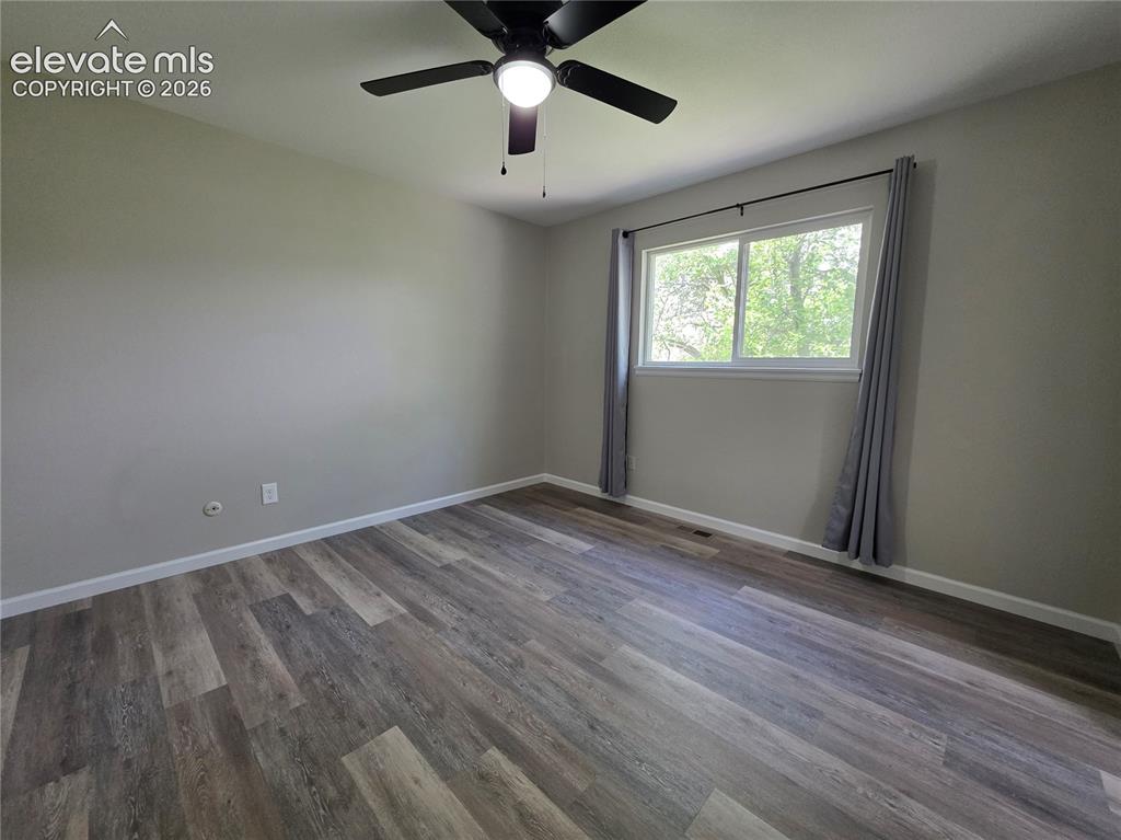 Image 7 of 18: Wood-finish flooring, neutral wall tones, and a ceiling fan with integrated