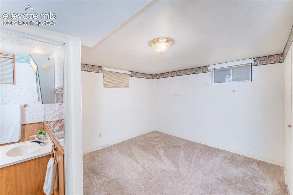 Image 16 of 29: Carpeted room featuring a ceiling-mounted light fixture, and a window with