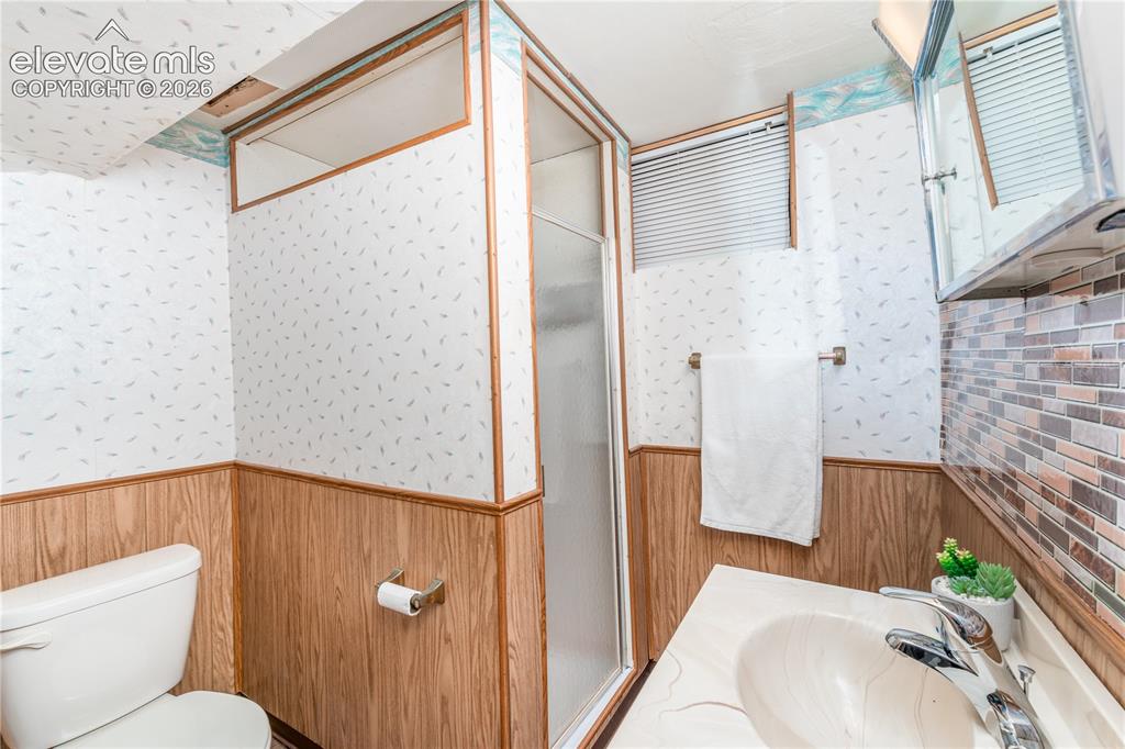 Image 17 of 29: Bathroom featuring a shower enclosure with a frosted panel, a toilet, a van