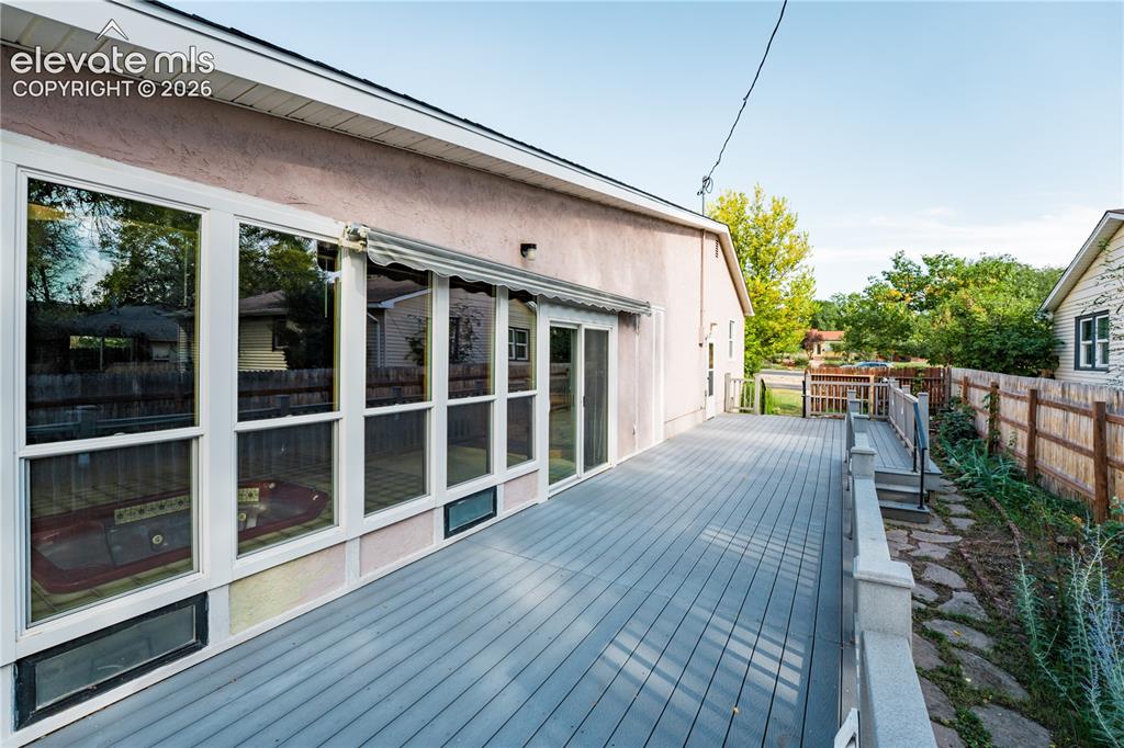 Image 22 of 29: Expansive outdoor deck with gray composite decking, white railings, and a p