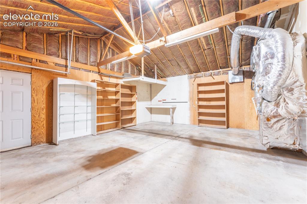 Image 24 of 29: Concrete flooring with exposed wood beam ceiling