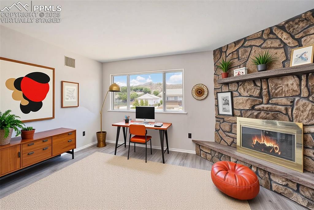Image 10 of 35: Office space with wood burning fireplace, virtually staged.